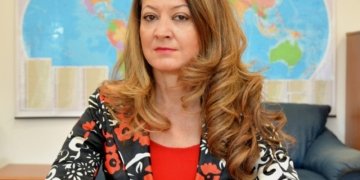 Жена с дълга коса и усмивка.